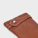 Handcrafted from smooth caramel lambskin and lined with natural beige cashmere. Finished with a decorative, hand-stitched leather strap in contrasting beige thread. Featuring the signature brass logo closure in silver, nickel-free and protected with a durable, polished finish. Made in an artisanal workshop in Italy. Available in sizes 7, 7.5, 8, 8.5, 9, 9.5 (Italian sizing).