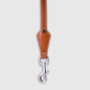 Hand-stitched from smooth, natural calfskin in an artisan workshop in the EU. Characterized by Pattmond’s signature shape, distinguished by subtle shifts in width and refined ornamental details. Caramel-coloured, vegetable-tanned leather with beige contrast stitching and a brown lining inside the handle. Solid brass hardware in silver (signature snap hook and logo studs), nickel-free and protected with a durable, polished finish. With a fixed length of 175 cm and a width of: - 1.5 cm, it is proportioned for smaller and medium dogs - 2.2 cm, it is proportioned for larger dogs.