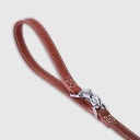 Hand-stitched from smooth, natural calfskin in an artisan workshop in the EU. Characterized by Pattmond’s signature shape, distinguished by subtle shifts in width and refined ornamental details. Caramel-coloured, vegetable-tanned leather with beige contrast stitching. Solid brass hardware in silver (signature snap hook and logo studs), nickel-free and protected with a durable, polished finish. Adjustable length of 230 cm, 150 cm, and 115 cm. With a width of: - 1.5 cm, it is proportioned for smaller and medium dogs - 2.2 cm, it is proportioned for larger dogs.