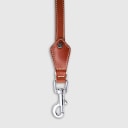 Hand-stitched from smooth, natural calfskin in an artisan workshop in the EU. Characterized by Pattmond’s signature shape, distinguished by subtle shifts in width and refined ornamental details. Caramel-coloured, vegetable-tanned leather with beige contrast stitching. Solid brass hardware in silver (signature snap hook and logo studs), nickel-free and protected with a durable, polished finish. Adjustable length of 230 cm, 150 cm, and 115 cm. With a width of: - 1.5 cm, it is proportioned for smaller and medium dogs - 2.2 cm, it is proportioned for larger dogs.