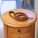 Hand-stitched from smooth, natural calfskin in an artisan workshop in the EU. Characterized by Pattmond’s signature shape, distinguished by subtle shifts in width and refined ornamental details. Caramel-coloured, vegetable-tanned leather with beige contrast stitching and a brown lining inside the handle. Solid brass hardware in silver (signature snap hook and logo studs), nickel-free and protected with a durable, polished finish. With a fixed length of 175 cm and a width of: - 1.5 cm, it is proportioned for smaller and medium dogs - 2.2 cm, it is proportioned for larger dogs.