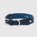 A dog collar in vegan cactus leather, handmade in a Polish artisan workshop. Designed by the Italian designer Francesco Rigucci, it is recognisable by its signature shape and the jewellery-like metal studs carrying the brand logo. The outer layer is navy cactus leather with matching navy stitching, over soft padding and a cobalt cactus leather lining. The D-ring, buckle and logo studs are solid brass in silver finish, nickel-free and protected with a durable polished coating. Adjustable length – check the measurements to choose the right size for your dog. Available on its own or as a set with the matching cactus leather leash.
