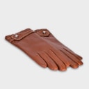 Gloves in natural caramel lambskin, made in an Italian artisan workshop. Designed by the Italian designer Francesco Rigucci. Sewn from smooth lambskin, prized for its exceptional softness, and lined with natural beige cashmere. Finished with a hand-sewn leather strap and decorative beige stitching. The signature solid brass fastening comes in silver finish, nickel-free and protected with a durable polished coating. Available in sizes 7, 7.5 and 8 (the size matches the hand circumference in inches).