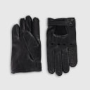 Gloves in natural black lambskin, made in an Italian artisan workshop. Designed by the Italian designer Francesco Rigucci. Entirely hand-sewn from smooth lambskin, prized for its exceptional softness. They are unlined, which makes them just as wearable on milder days. The cut-out at the wrist gives them their modern shape. The signature solid brass fastening comes in gunmetal finish, nickel-free and protected with a durable polished coating. Available in sizes 7, 7.5, 8, 8.5, 9 and 9.5 (the size matches the hand circumference in inches).