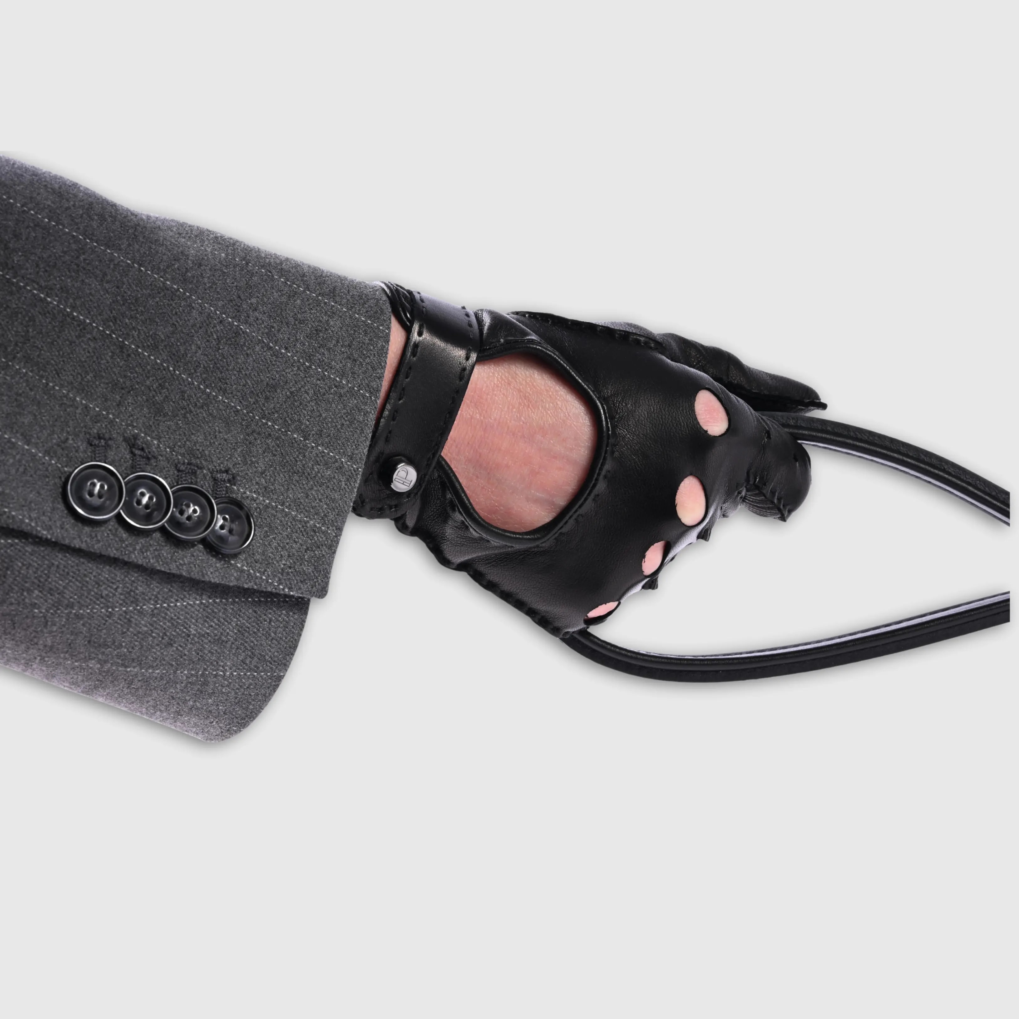 Gloves in natural black lambskin, made in an Italian artisan workshop. Designed by the Italian designer Francesco Rigucci. Entirely hand-sewn from smooth lambskin, prized for its exceptional softness. They are unlined, which makes them just as wearable on milder days. The cut-out at the wrist gives them their modern shape. The signature solid brass fastening comes in gunmetal finish, nickel-free and protected with a durable polished coating. Available in sizes 7, 7.5, 8, 8.5, 9 and 9.5 (the size matches the hand circumference in inches).