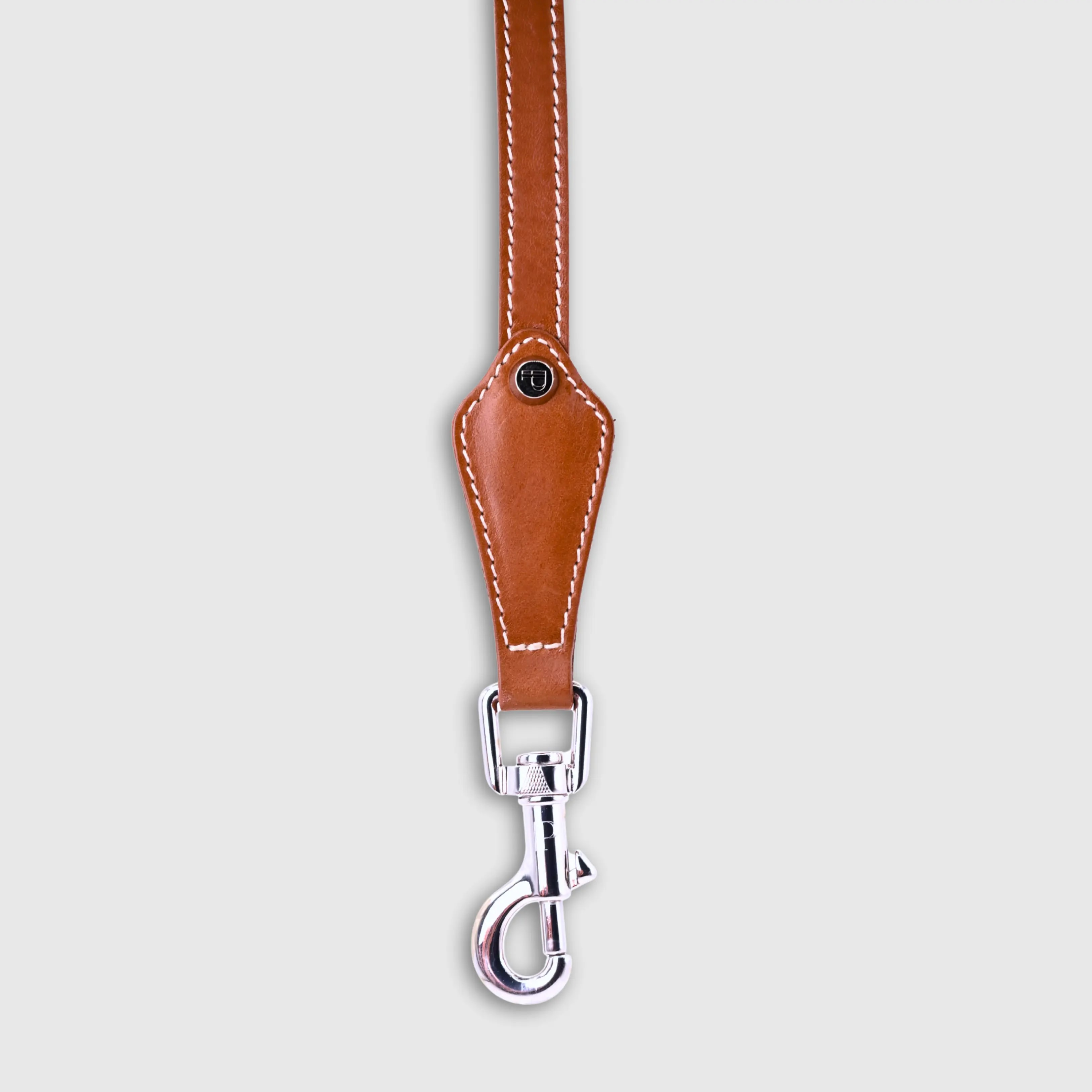 Hand-stitched from smooth, natural calfskin in an artisan workshop in the EU. Characterized by Pattmond’s signature shape, distinguished by subtle shifts in width and refined ornamental details. Caramel-coloured, vegetable-tanned leather with beige contrast stitching and a brown lining inside the handle. Solid brass hardware in silver (signature snap hook and logo studs), nickel-free and protected with a durable, polished finish. With a fixed length of 175 cm and a width of: - 1.5 cm, it is proportioned for smaller and medium dogs - 2.2 cm, it is proportioned for larger dogs.