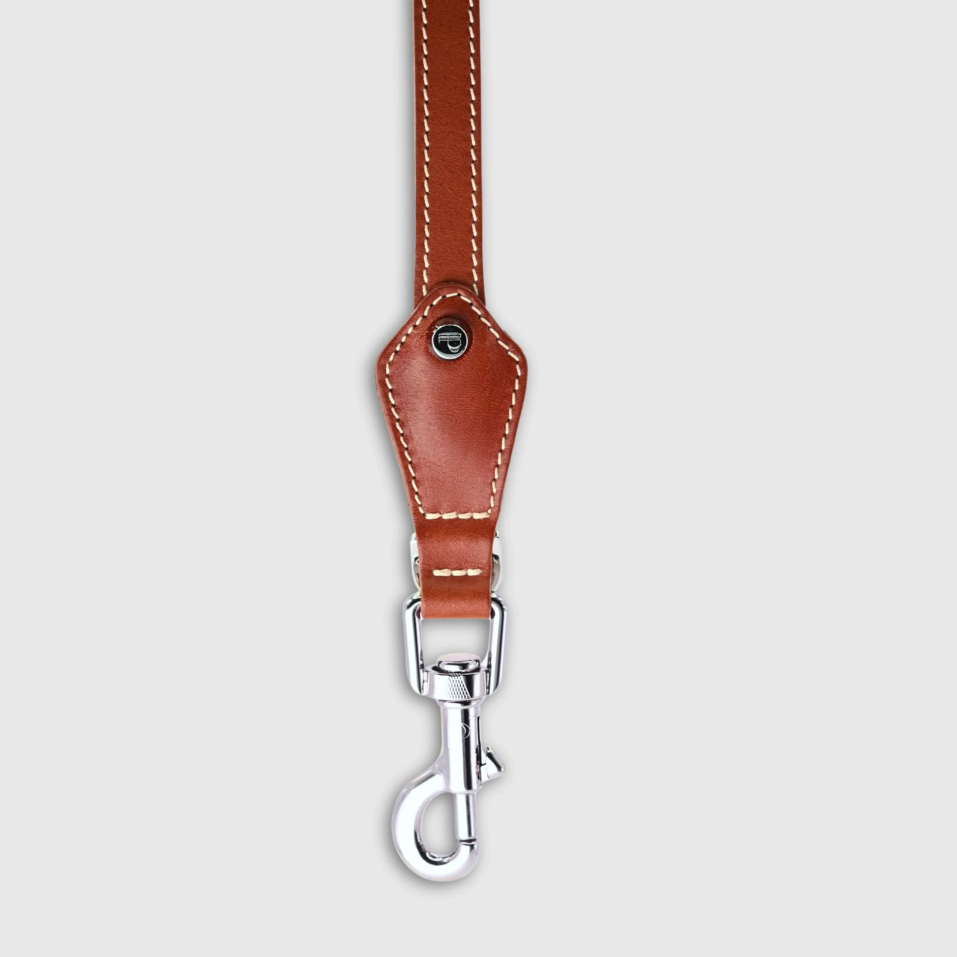 Hand-stitched from smooth, natural calfskin in an artisan workshop in the EU. Characterized by Pattmond’s signature shape, distinguished by subtle shifts in width and refined ornamental details. Caramel-coloured, vegetable-tanned leather with beige contrast stitching. Solid brass hardware in silver (signature snap hook and logo studs), nickel-free and protected with a durable, polished finish. Adjustable length of 230 cm, 150 cm, and 115 cm. With a width of: - 1.5 cm, it is proportioned for smaller and medium dogs - 2.2 cm, it is proportioned for larger dogs.