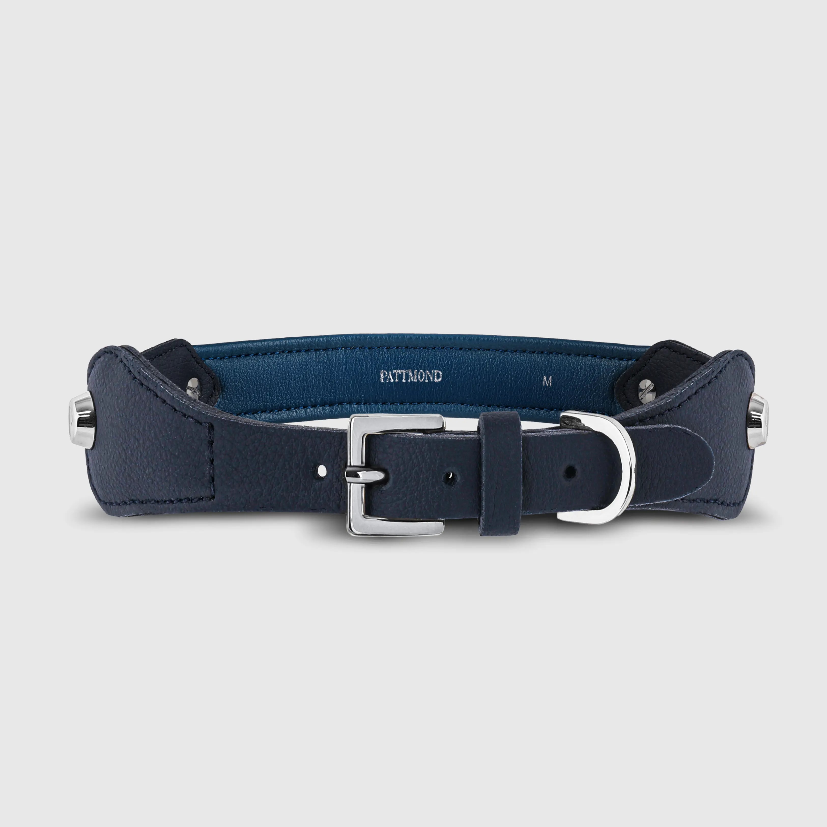 Hand-stitched from grained, cactus-based “leather” in an artisan workshop in the EU. Characterized by Pattmond’s signature shape, distinguished by subtle shifts in width and refined ornamental details. Navy exterior with matching navy stitching and a royal blue lining. Solid brass hardware in silver (D-ring for the leash, buckle and signature logo studs), nickel-free and protected with a durable, polished finish. Adjustable length (see dimensions to choose the best fit for your dog). Available individually or in a set with a matching cactus-based “leather” leash.