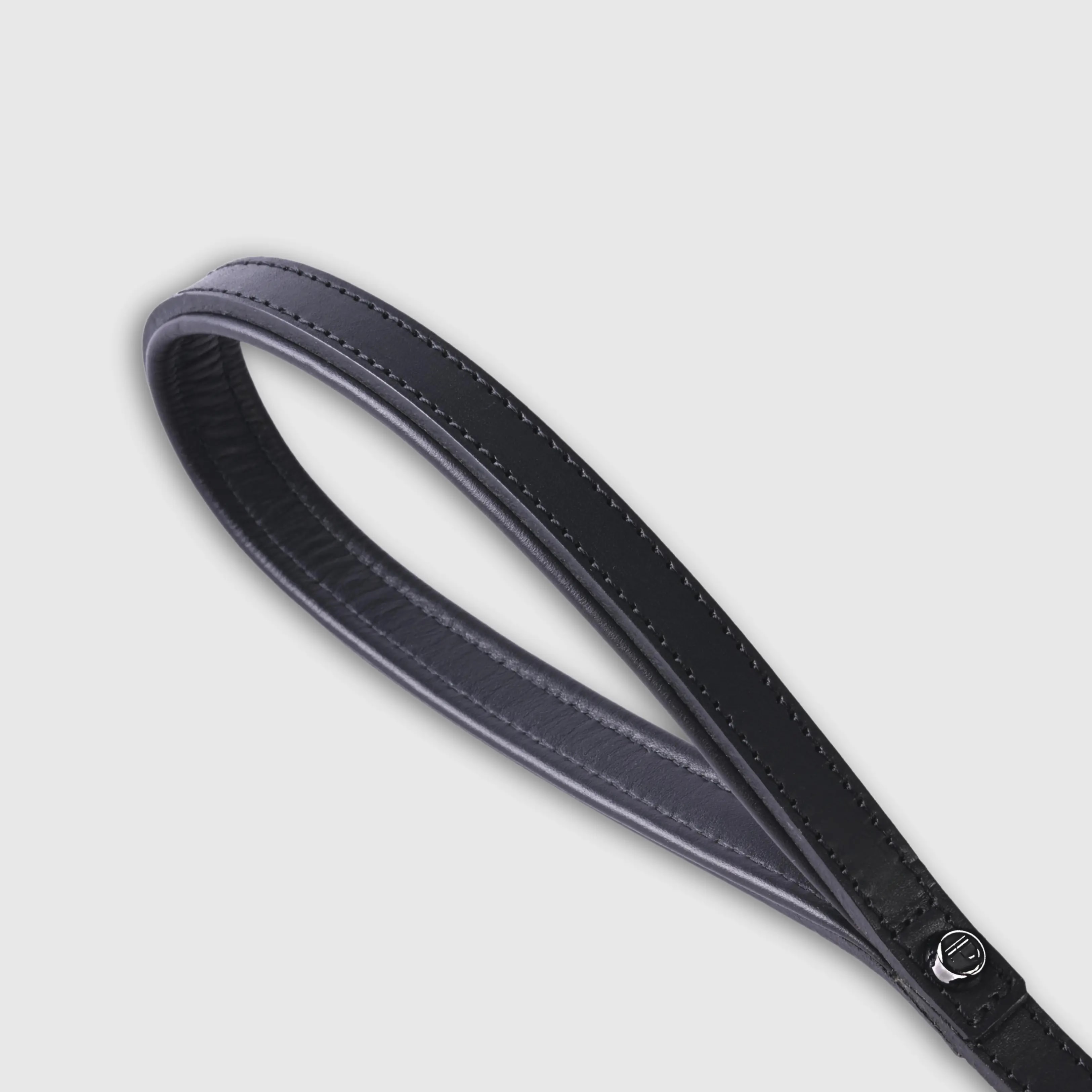 Hand-stitched from smooth natural calfskin in an artisan workshop in the EU. Characterized by Pattmond’s signature shape, distinguished by subtle shifts in width and refined ornamental details. Black-coloured leather with matching black stitching and a black lining inside the handle. Solid brass hardware with a gunmetal finish (signature snap hook and logo studs), nickel-free and protected with a durable, polished finish. With a fixed length of 175 cm and a width of 2.2 cm, it is proportioned for larger dogs.