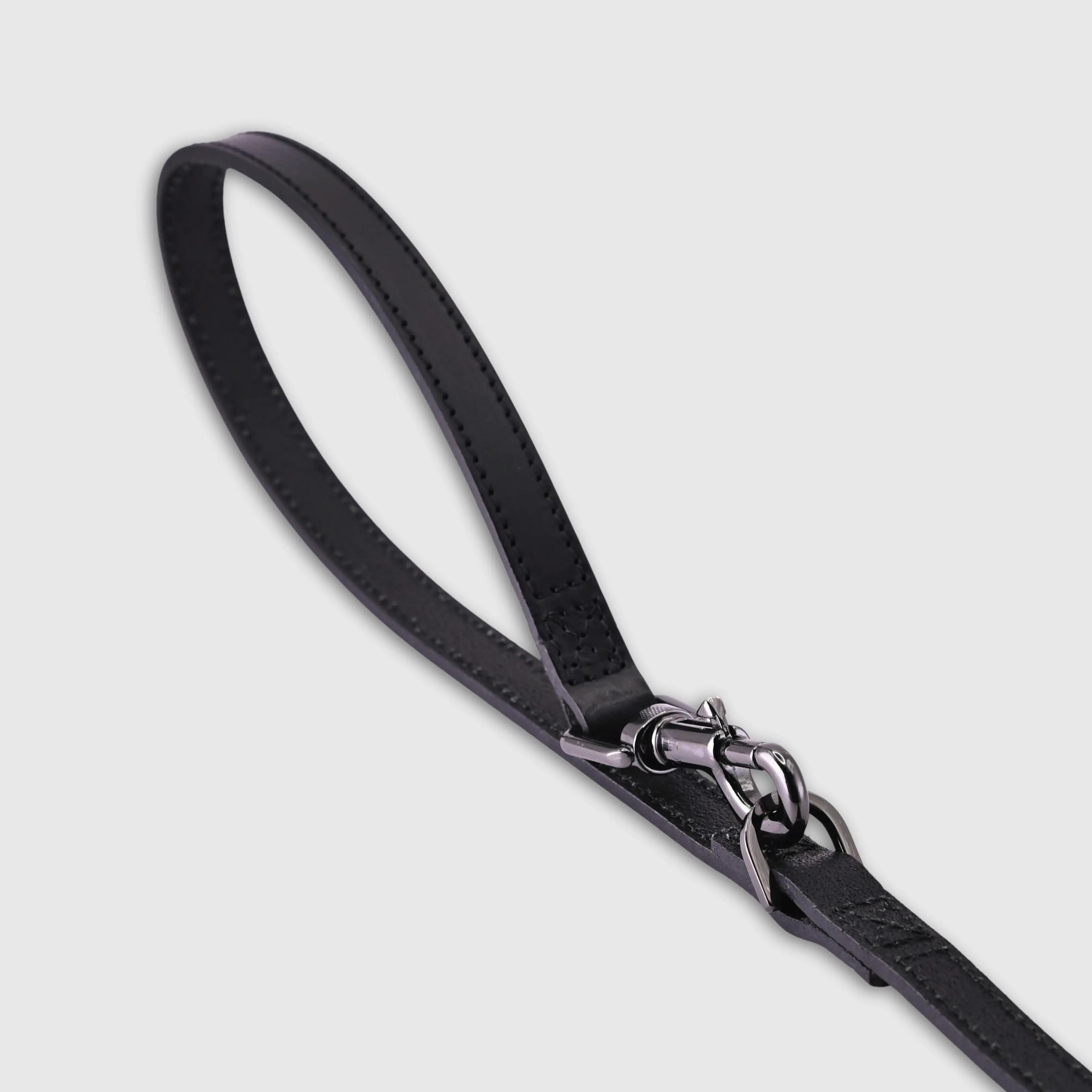 Hand-stitched from smooth, natural calfskin in an artisan workshop in the EU. Characterized by Pattmond’s signature shape, distinguished by subtle shifts in width and refined ornamental details. Black, vegetable-tanned leather with matching black stitching. Solid brass hardware in silver (signature snap hook and logo studs), nickel-free and protected with a durable, polished finish. Adjustable length of 230 cm, 150 cm, and 115 cm. With a width of 2.2 cm, it is proportioned for larger dogs.