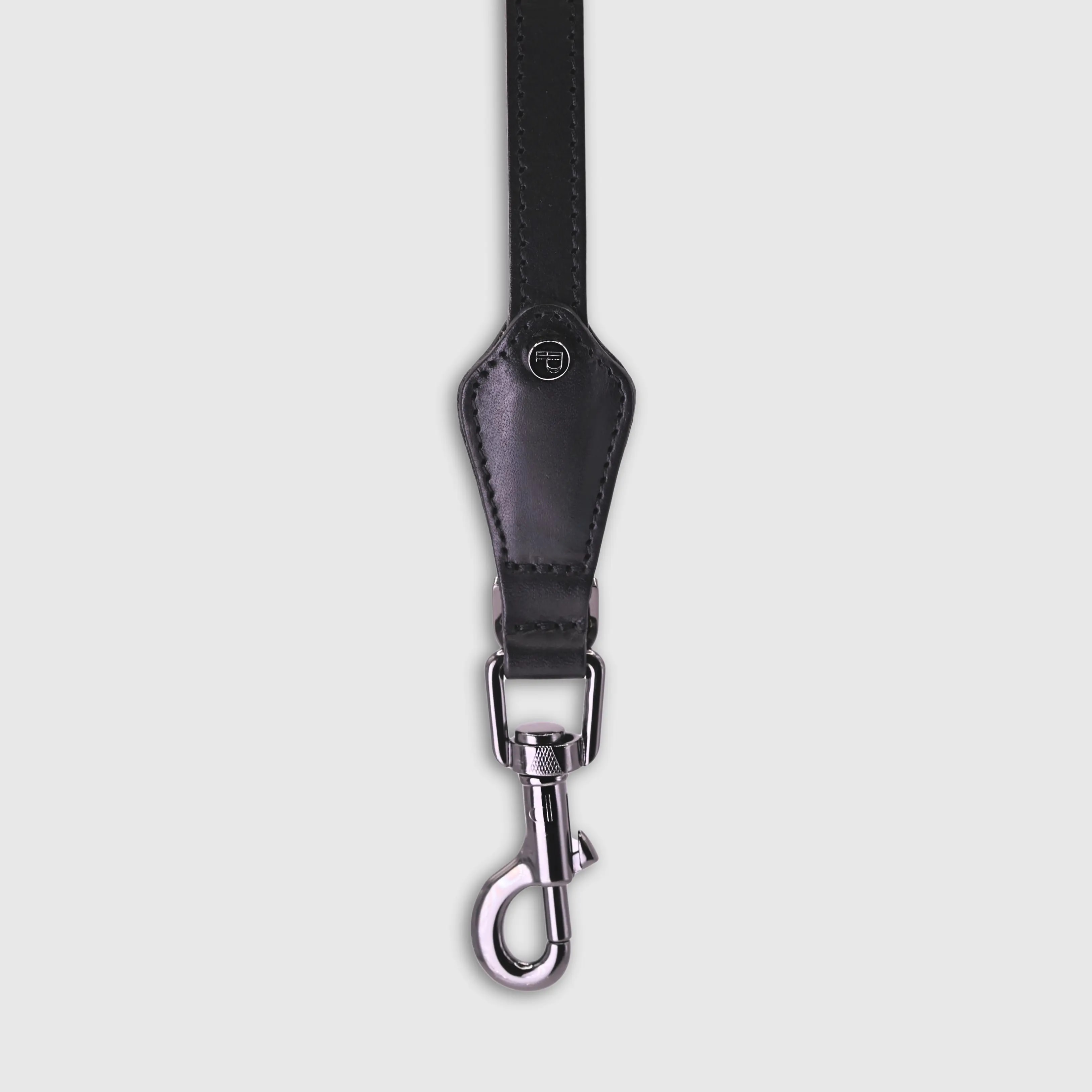 Hand-stitched from smooth, natural calfskin in an artisan workshop in the EU. Characterized by Pattmond’s signature shape, distinguished by subtle shifts in width and refined ornamental details. Black, vegetable-tanned leather with matching black stitching. Solid brass hardware in silver (signature snap hook and logo studs), nickel-free and protected with a durable, polished finish. Adjustable length of 230 cm, 150 cm, and 115 cm. With a width of 2.2 cm, it is proportioned for larger dogs.