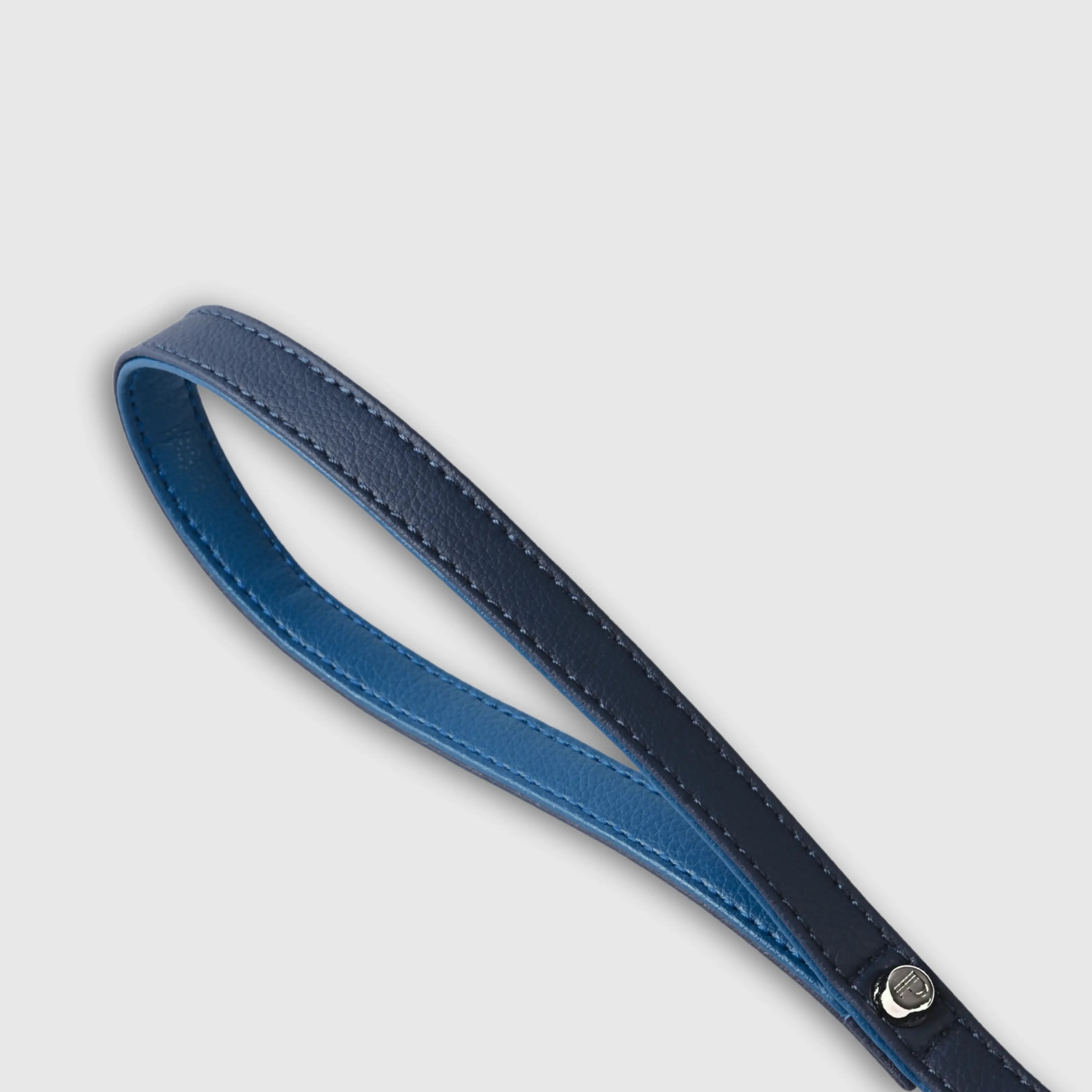 Hand-stitched from grained, cactus vegan leather in an artisan workshop in the EU. Characterized by Pattmond’s signature shape, distinguished by subtle shifts in width and refined ornamental details. Navy cactus-based “leather” with matching navy stitching and a royal blue lining inside the handle. Solid brass hardware in silver (signature snap hook and logo studs), nickel-free and protected with a durable, polished finish. With a fixed length of 175 cm and a width of 2.2 cm, it is proportioned for larger dogs.