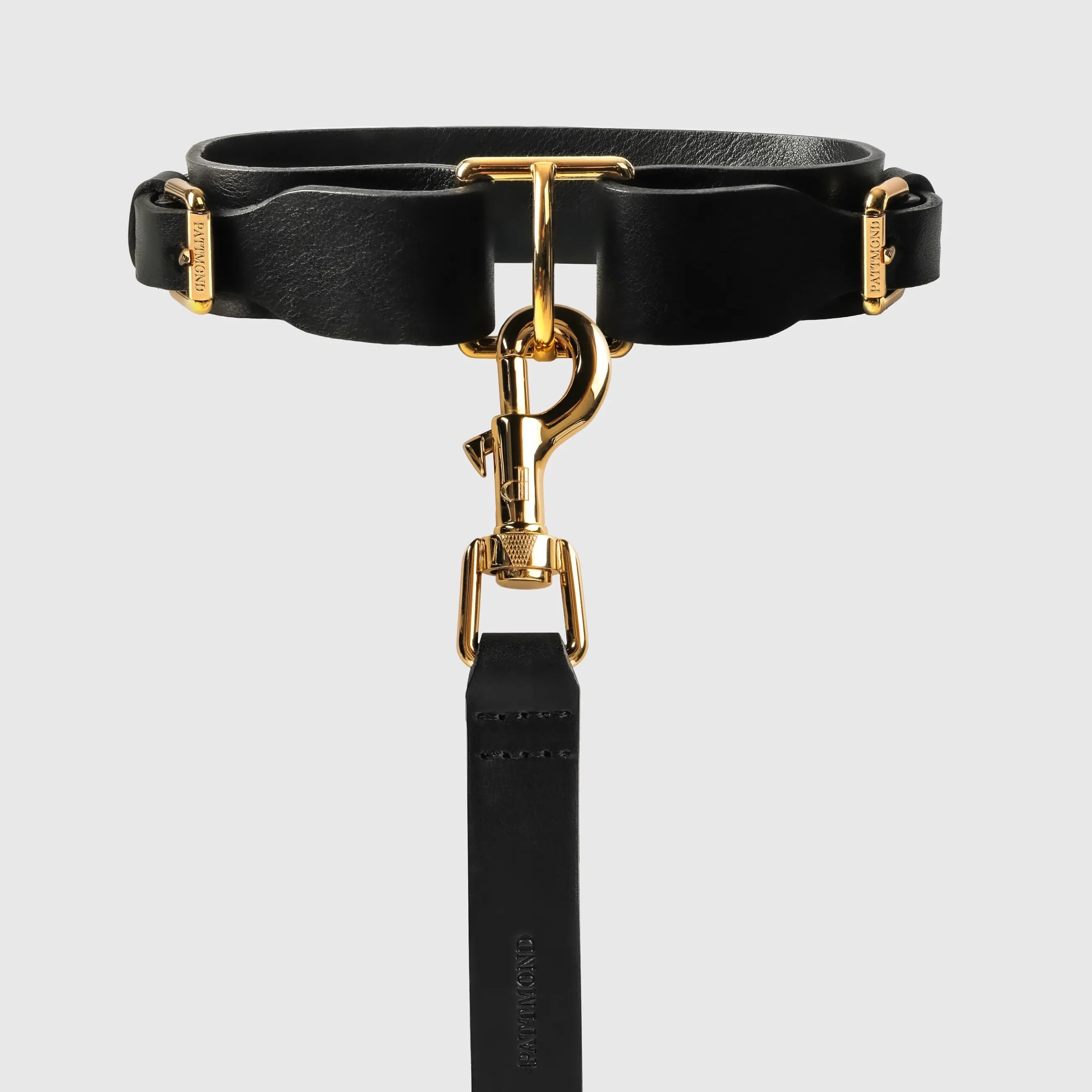 A dog collar in natural bovine leather, hand-sewn in a Polish artisan workshop. Raw edges and clean lines bring out the natural character of vegetable-tanned leather. The collar is defined by its solid brass hardware, nickel-free and made to order for Pattmond by an Italian manufacturer. The polished gold finish gives it a jewellery-like quality. A distinctive metal piece at the centre of the collar makes clipping on the leash easy, and two side buckles with the Pattmond logo allow a precise fit. Available on its own or as a set with the matching leather leash.